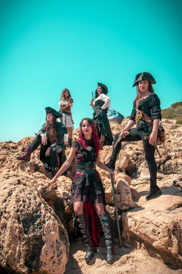 Las cinco integrantes de Pirate Queen con vestuario pirata junto al mar