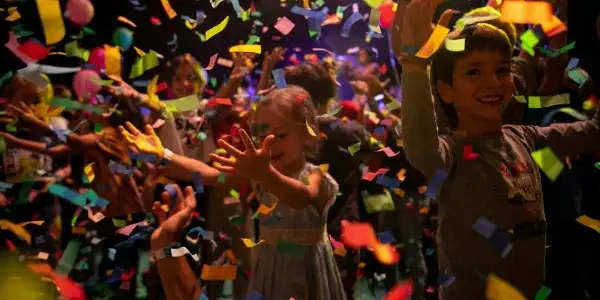 Nens i nenes celebrant amb confeti al Festival Petits Camaleons